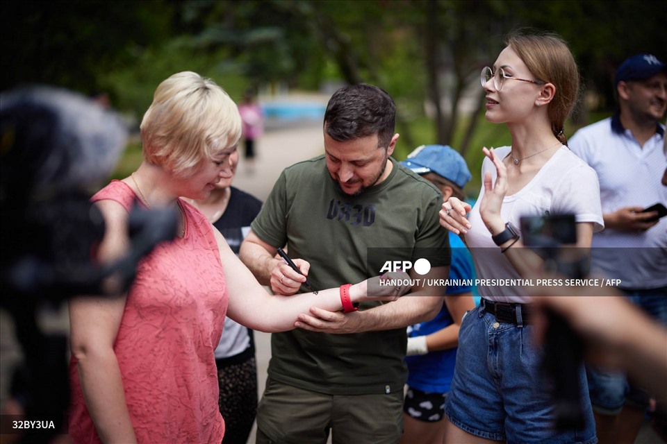 Ukrainian President Volodymyr Zelensky signs a woman's arm as he visits a clinic in the Zaporizhzhia region.  Photo: AFP
