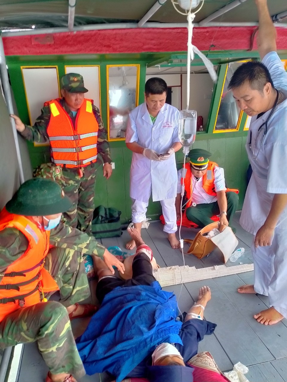 Lực lượng Biên phòng và y bác sỹ Trung tâm y tế Bạch Long Vỹ cấp cứu nạn nhân bị cá mập tấn công. Ảnh: Sơn Hà