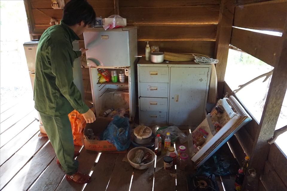 Một bảo vệ rừng kiểm tra lại thức ăn, vật dụng trong tủ lạnh đã hỏng. Ảnh T.T