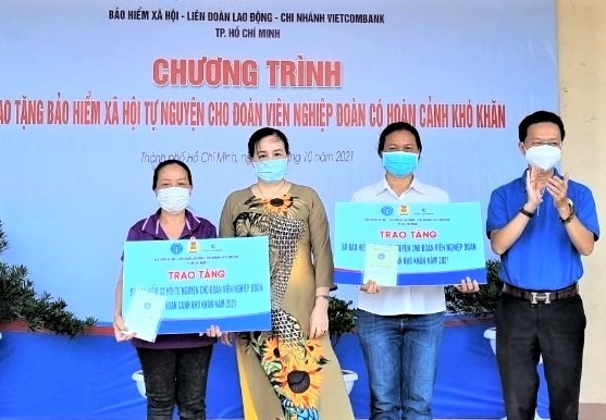 Đại diện LĐLĐ TPHCM và BHXH TPHCM tặng sổ BHXH tự nguyện cho đoàn viên nghiệp đoàn giúp việc nhà quận Tân Phú có hoàn cảnh khó khăn. Ảnh: Nam Dương