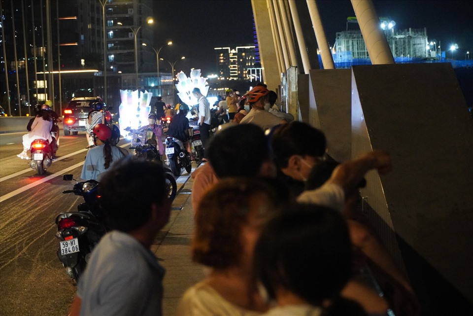Ghi nhận của Lao Động trong tối ngày 16.7, trong khoảng thời gian từ 20h-21h, tại cầu Thủ Thiêm 2 có rất đông người dân tập trung tại đây. Phần lớn người dân đều điều khiển xe lên giữa cầu rồi dừng xe trên mặt đường cầu để lên vỉa hè chụp ảnh, vui chơi.