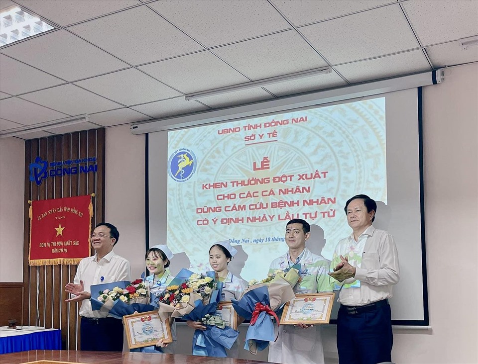Phó giám đốc Sở Y tế Nguyễn Văn Bình và Giám đốc Bệnh viện Đa khoa Đồng Nai Ngô Đức Tuấn trao giấy khen, tặng hoa cho 2 điều dưỡng và bác sĩ. Ảnh: Hà Anh Chiến