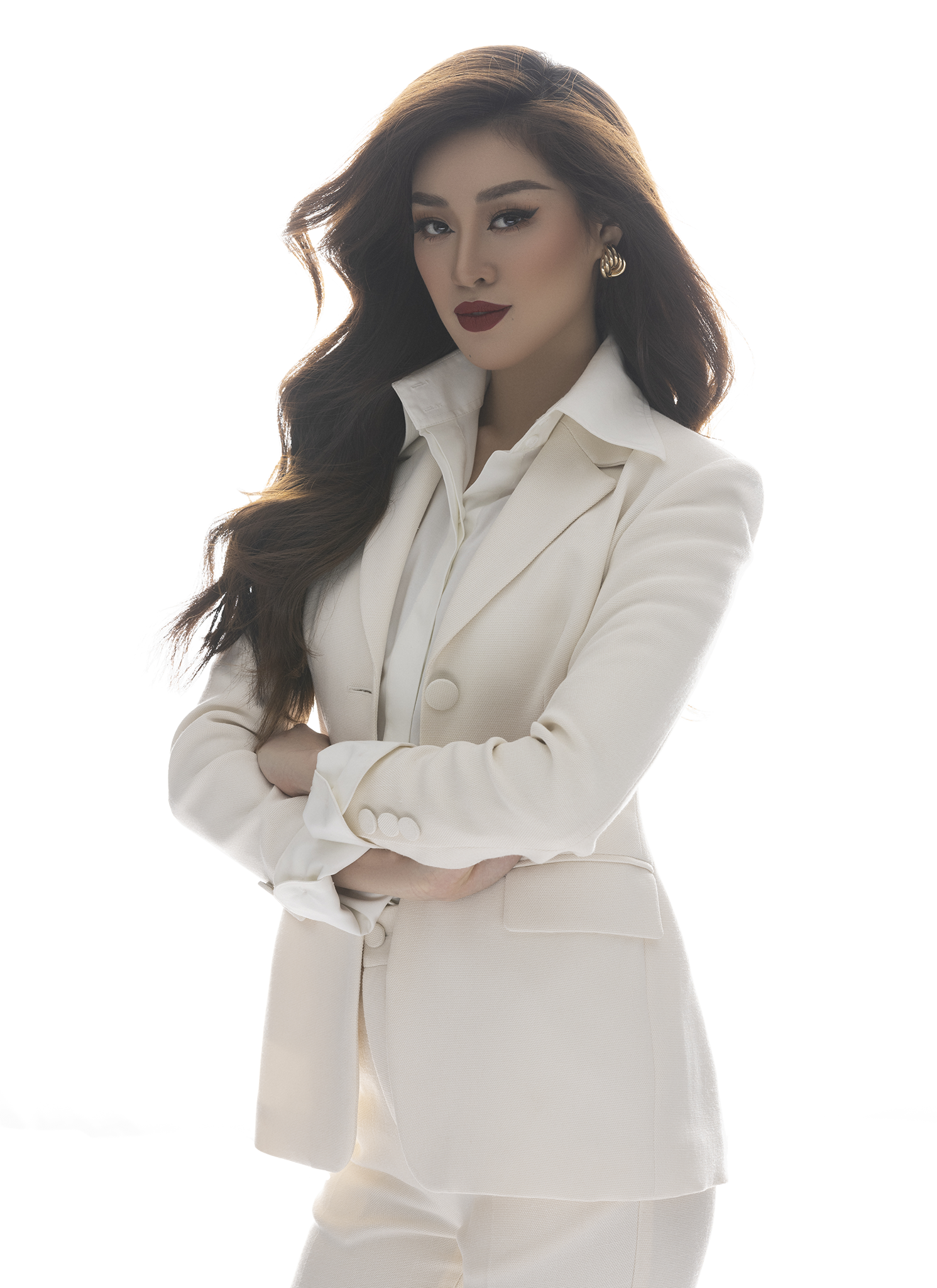 Với tone trang phục vest trắng, Khánh Vân chọn son môi đỏ đậm và tóc xoăn, gợi đến hình ảnh người phụ nữ hiện đại, tự tin,