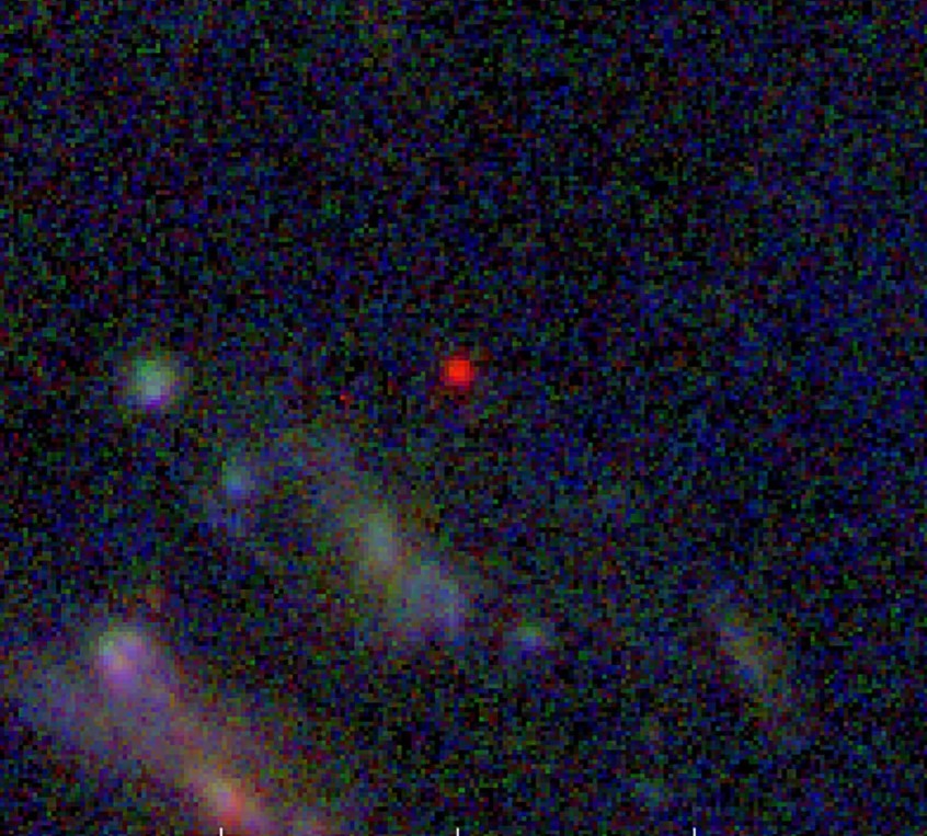 Khi chuyển từ tia hồng ngoại sang quang phổ khả kiến, thiên hà xuất hiện dưới dạng một đốm màu đỏ với màu trắng ở trung tâm. Ảnh: AFP