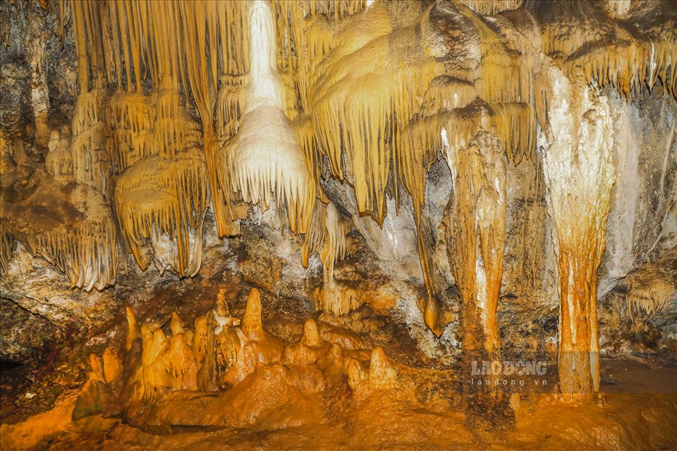 Hoa Sơn Thạch Động - điểm đến đầu tiên tại quần hang động, đây là một trong nhưng hang động khô, dài rộng và đẹp nhất của quần thể. Khi vào tham qua, du khách có thể bị choáng ngợp bởi cả rừng hoa thạch nhũ đua nhau khoe sắc. Nổi bật hơn cả là các khối nhũ đá lớn, cao sừng sững, nhuộm một màu vàng óng ánh, như cả một một núi vàng đang tuân chảy.