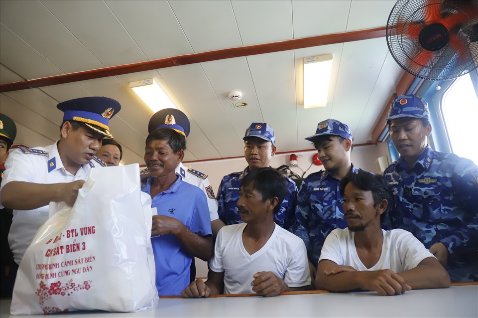 Cảnh sát biển tặng quà cho các ngư dân sau khi được họ vào bờ an toàn.