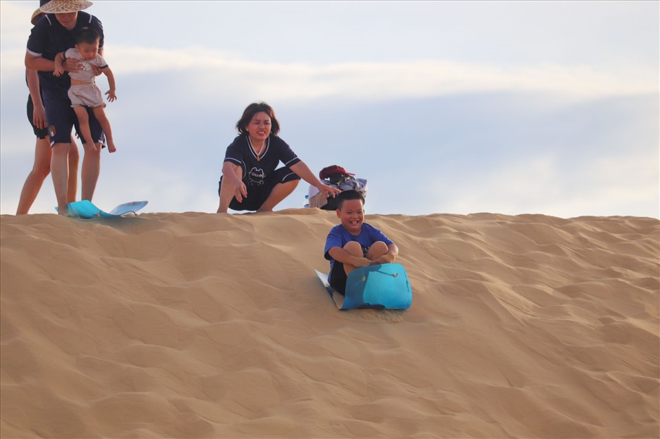 Nhiều em nhỏ hăng say trượt cát, chinh phục những đồi cát cao khác nhau tại đồi cát Quang Phú.