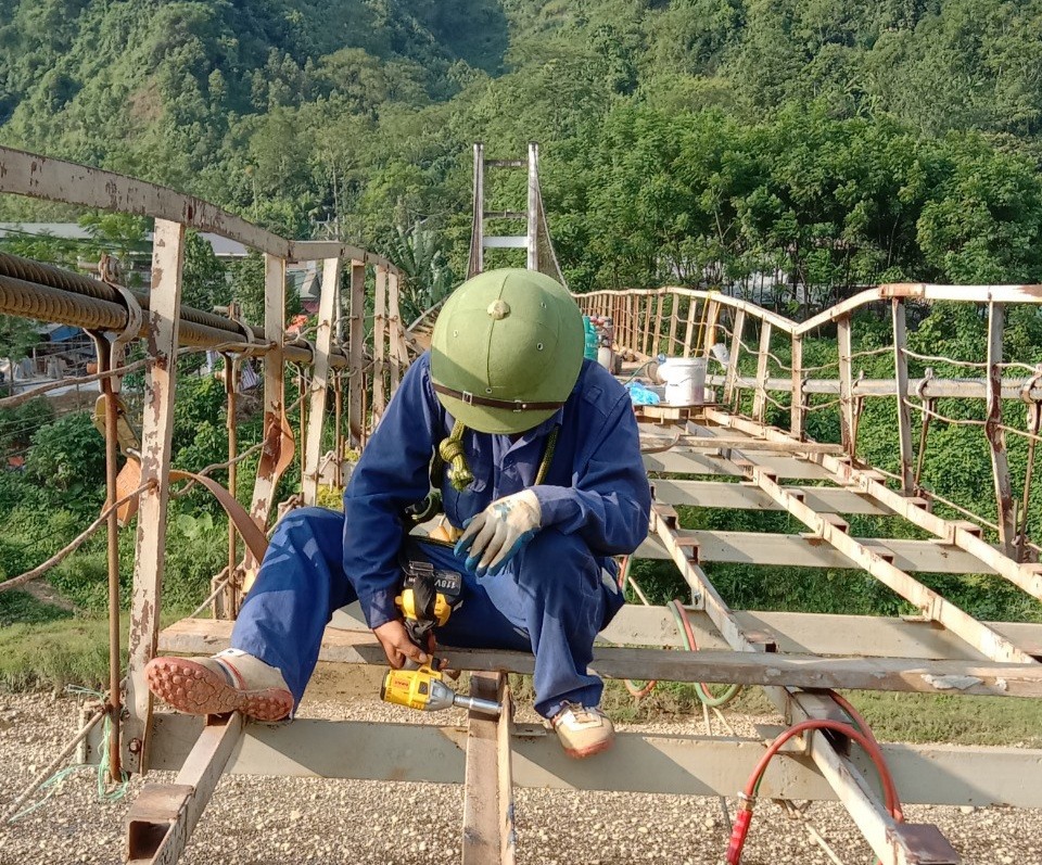 Các công nhân đang tích cực hàn, sửa các điểm nối để sớm gia cố lại cầu treo Yên Phú.