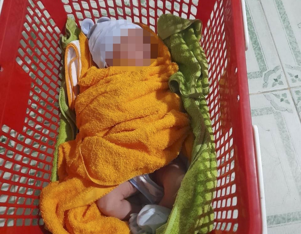 Bé sơ sinh được quấn trong khăn, đặt trong giỏ nhựa bỏ rơi ở trạm y tế. Ảnh: NDCC