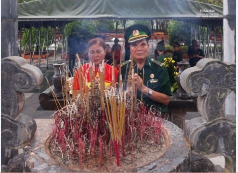 Chị Đinh Thị Minh Hùy cùng ông Đoàn Hải Yến dân hương trên Đài tưởng niệm Anh hùng liệt sỹ Pò Hèn.