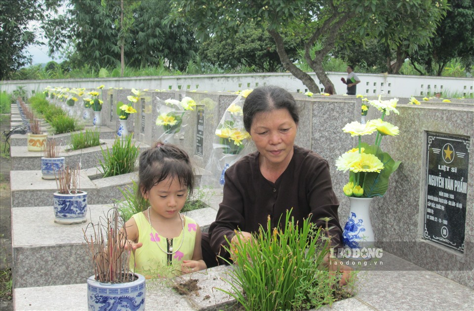 Bà cùng cháu gái đến thắp hương cho các phần mộ liệt sĩ.