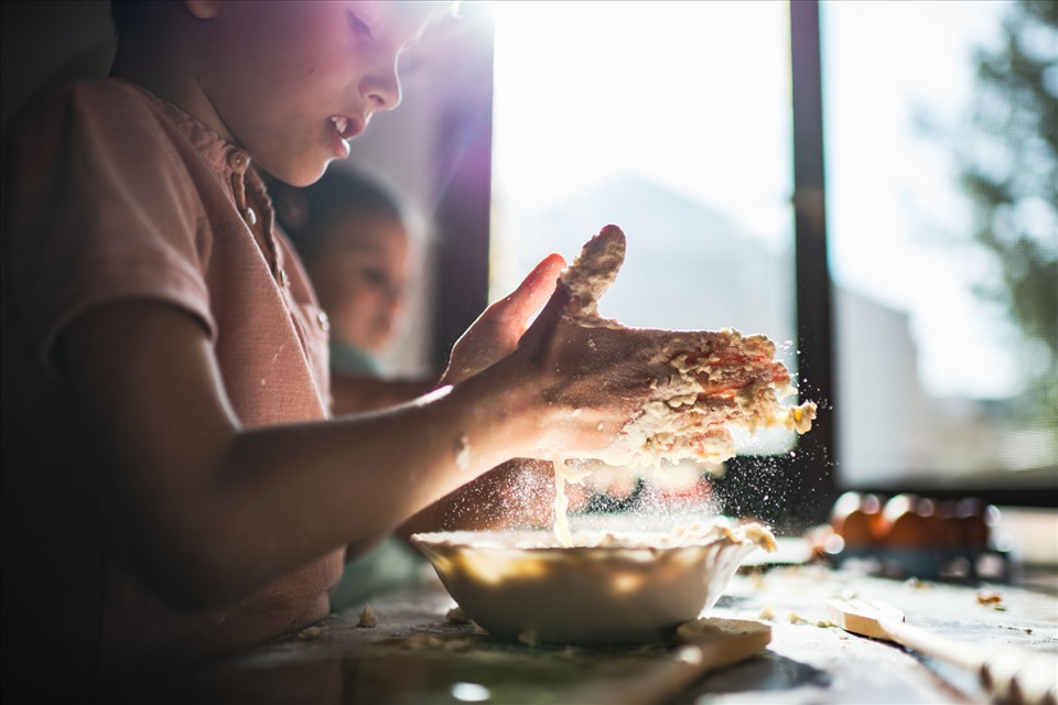 Trẻ sẽ trở nên khéo léo và tỉ mỉ khi được cha mẹ dạy nấu ăn. Ảnh: Xinhua