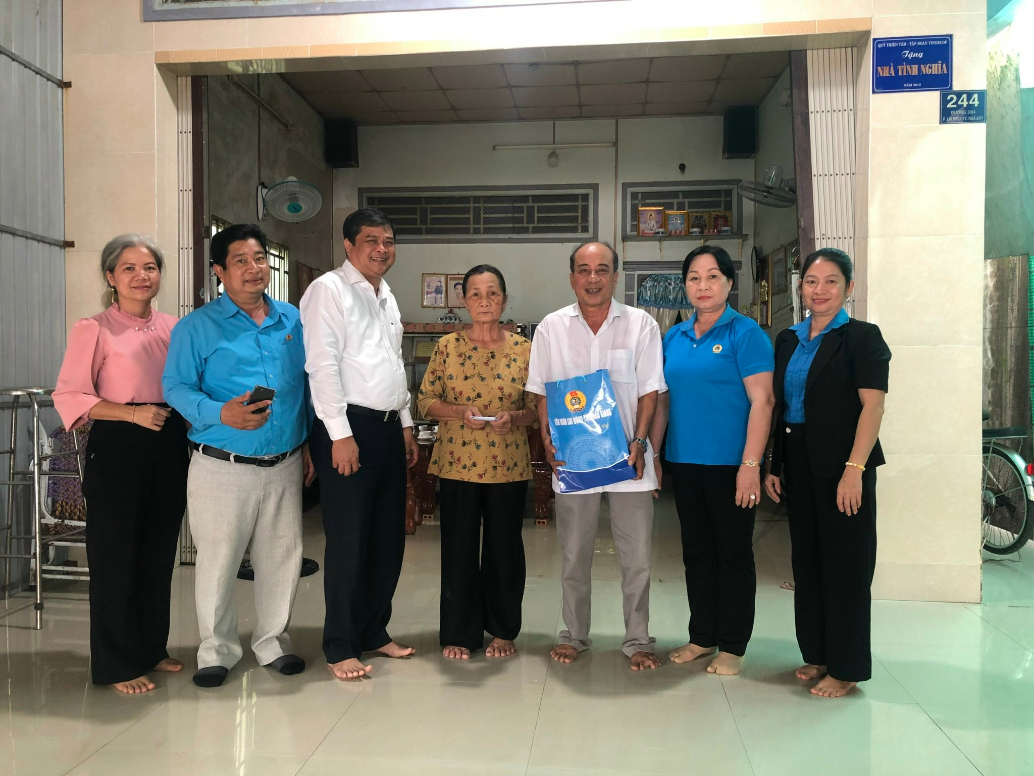 Ông Nguyễn Văn Bảy - Chủ tịch Liên đoàn Lao động tỉnh (áo trắng) tặng quà cho gia đình thương binh Phan Văn Nam