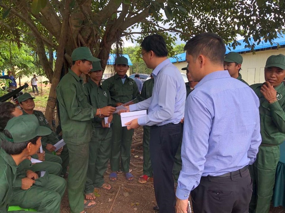 Thứ trưởng Phạm Quang Hiệu tặng quà cho các hộ dân đang làm việc tại nông trường của Công ty cao su VKETI- Lộc Ninh. Ảnh: BNG