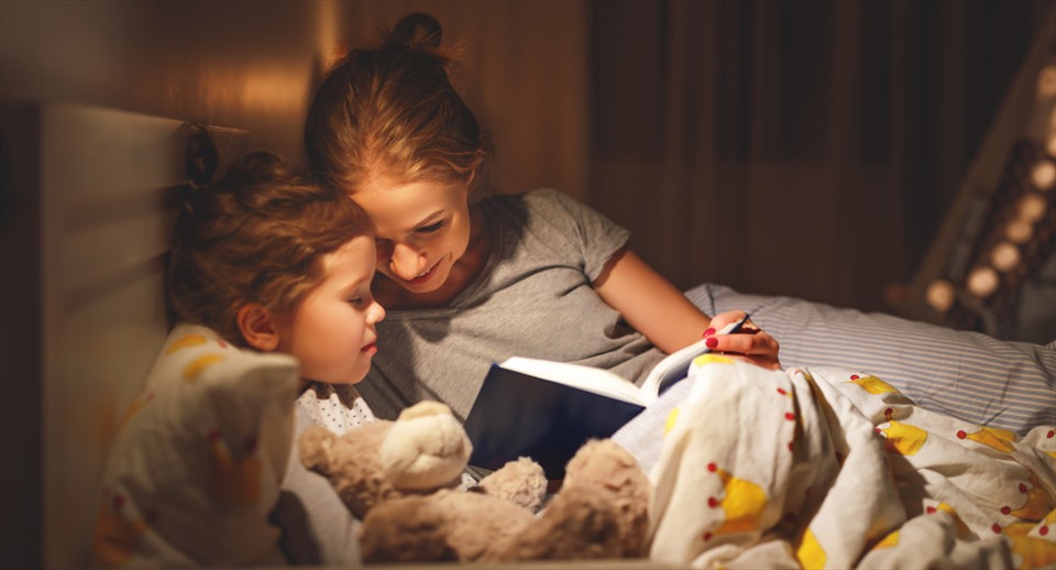 Hãy trò chuyện, đọc sách để giúp con có tâm lý thoải mái trước khi đi ngủ. Ảnh: Xinhua