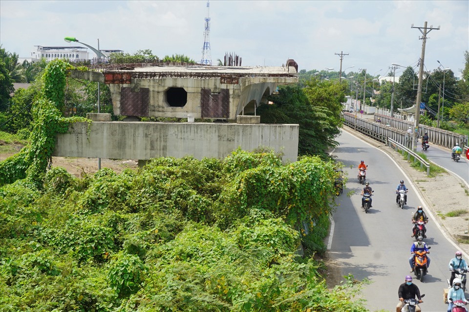 Do công trường dự án cầu Tăng Long bỏ hoang nhiều năm, cây dại mọc um tùm lên trụ và dầm cầu.   Ảnh: Minh Quân