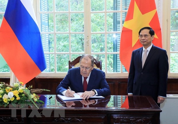 Bộ trưởng Ngoại giao Bùi Thanh Sơn chứng kiến Bộ trưởng Ngoại giao Nga Sergei Lavrov ghi lưu bút. Ảnh: TTXVN