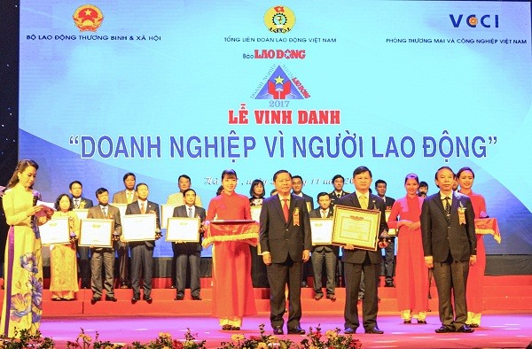 Ông Nguyễn Thanh Sơn Chủ tịch Công đoàn Công ty người ở giữa nhận Bằng khen của Bộ Lao đông TBXH và danh hiệu DN vì người lao động tại buổi lễ vinh danh