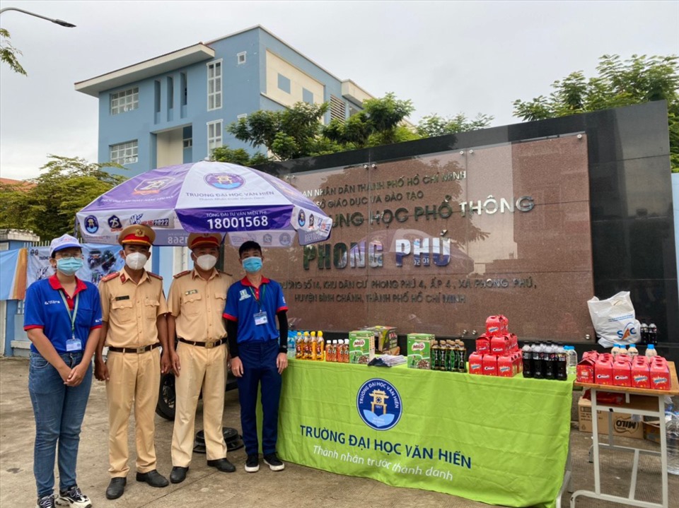 Cán bộ Trạm CSGT Đa Phước, Phòng PC08 có mặt tại trước cổng trường THPT Phong Phú, huyện Bình Chánh phát nước cho các thí sinh