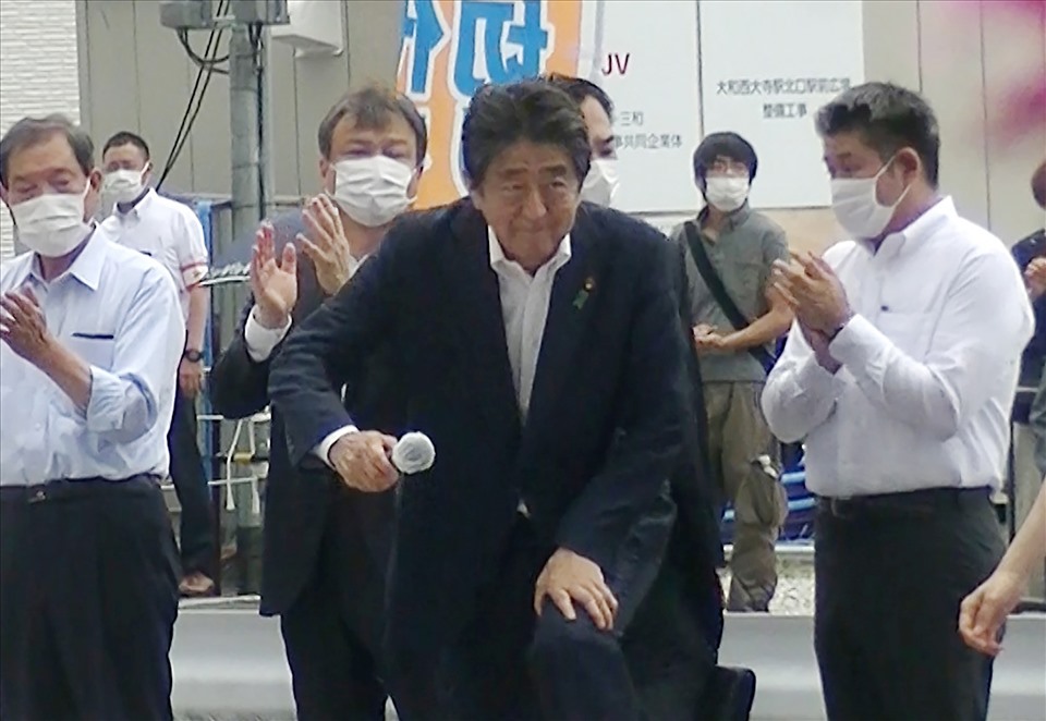 Cựu Thủ tướng Nhật Bản Shinzo Abe (giữa) bước xuống sau khi phát biểu vận động bầu cử tại quảng trường nhà ga Kintetsu Yamato-Saidaiji ở Nara. Nghi phạm bắn ông Abe là người thứ hai từ phải hàng sau. Ảnh: AFP