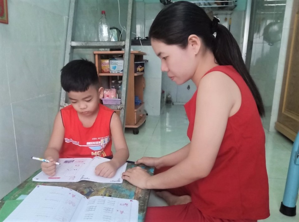 Chị Hương đang chăm con nhỏ học lúc ở nhà trọ. Ảnh: Đức Long