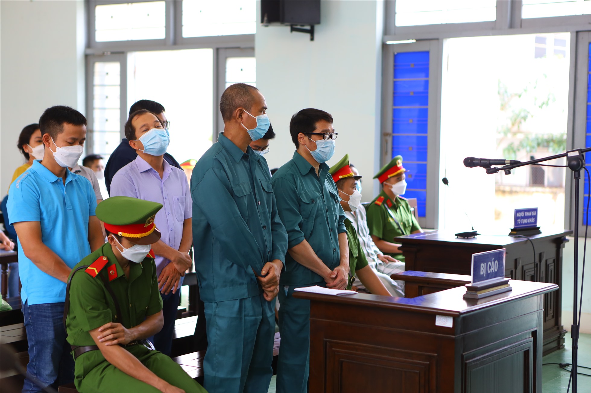 Luyện Xuân Tràng (đứng hàng đầu, đeo mắt kính) tại phiên tòa. Ảnh: DT