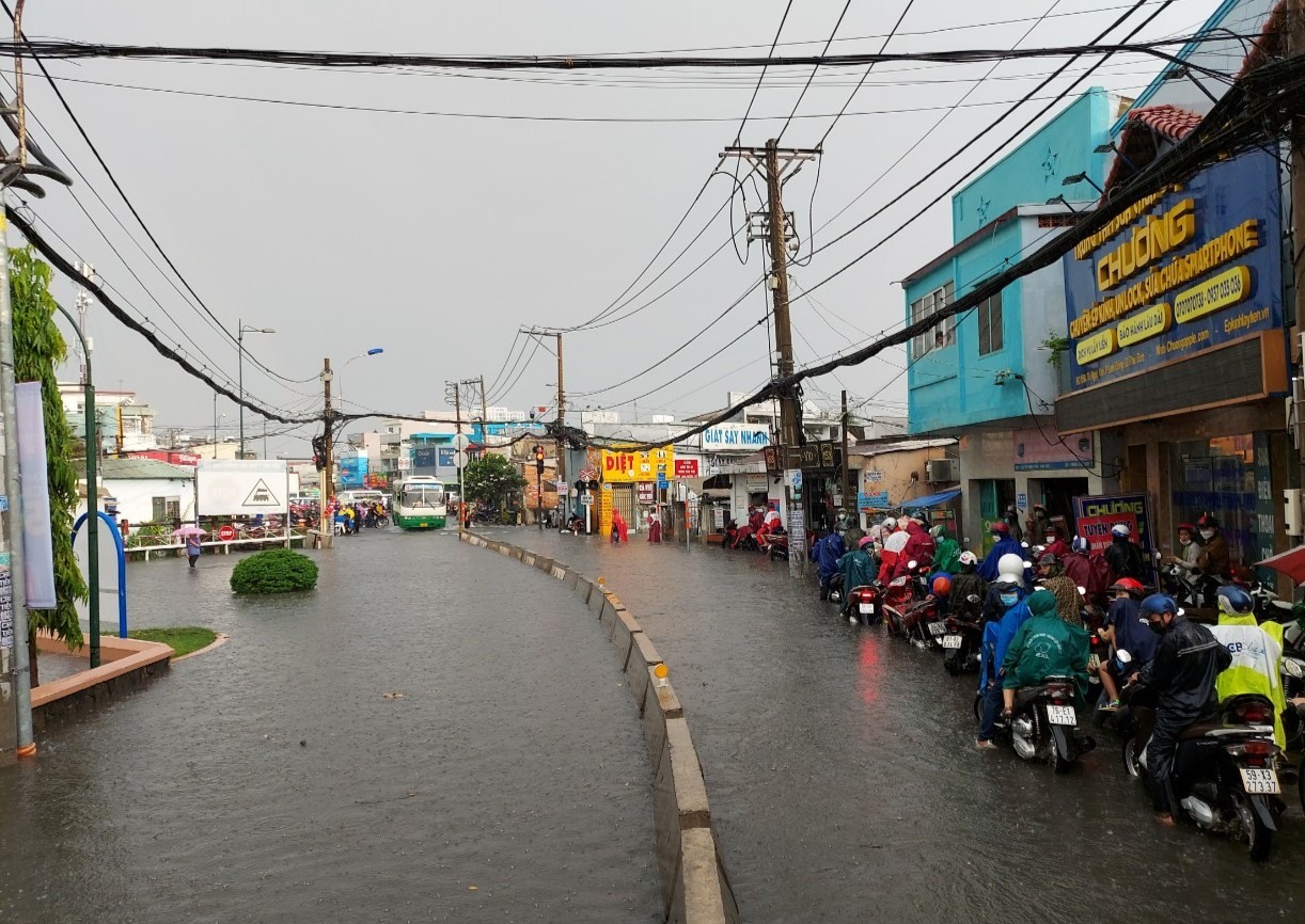 Khoảng 500 m đường Tô Ngọc Vân, đoạn gần giao lộ Phạm Văn Đồng (Thành phố Thủ Đức) mênh mông nước. Nhiều người đi xe máy phải tấp sát vỉa hè để tránh chết máy, chờ nước rút.