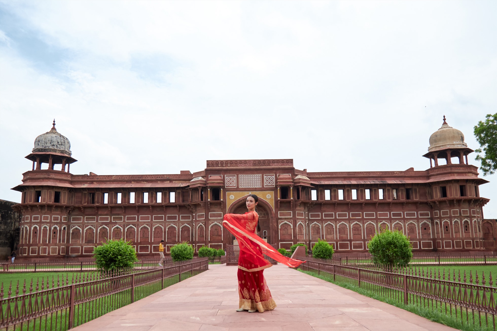 Với tone màu đỏ và vàng đồng của bộ trang phục, nàng hậu Thủy Tiên nổi bật giữa không gian kiến trúc của Taj Mahal và Red Fort