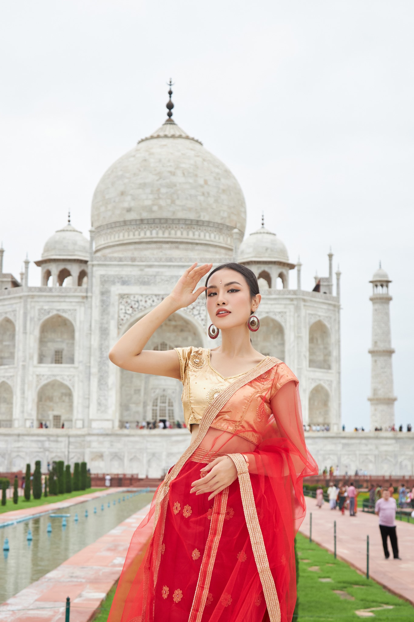 Với tone màu đỏ và vàng đồng của bộ trang phục, nàng hậu Thủy Tiên nổi bật giữa không gian kiến trúc của Taj Mahal và Red Fort