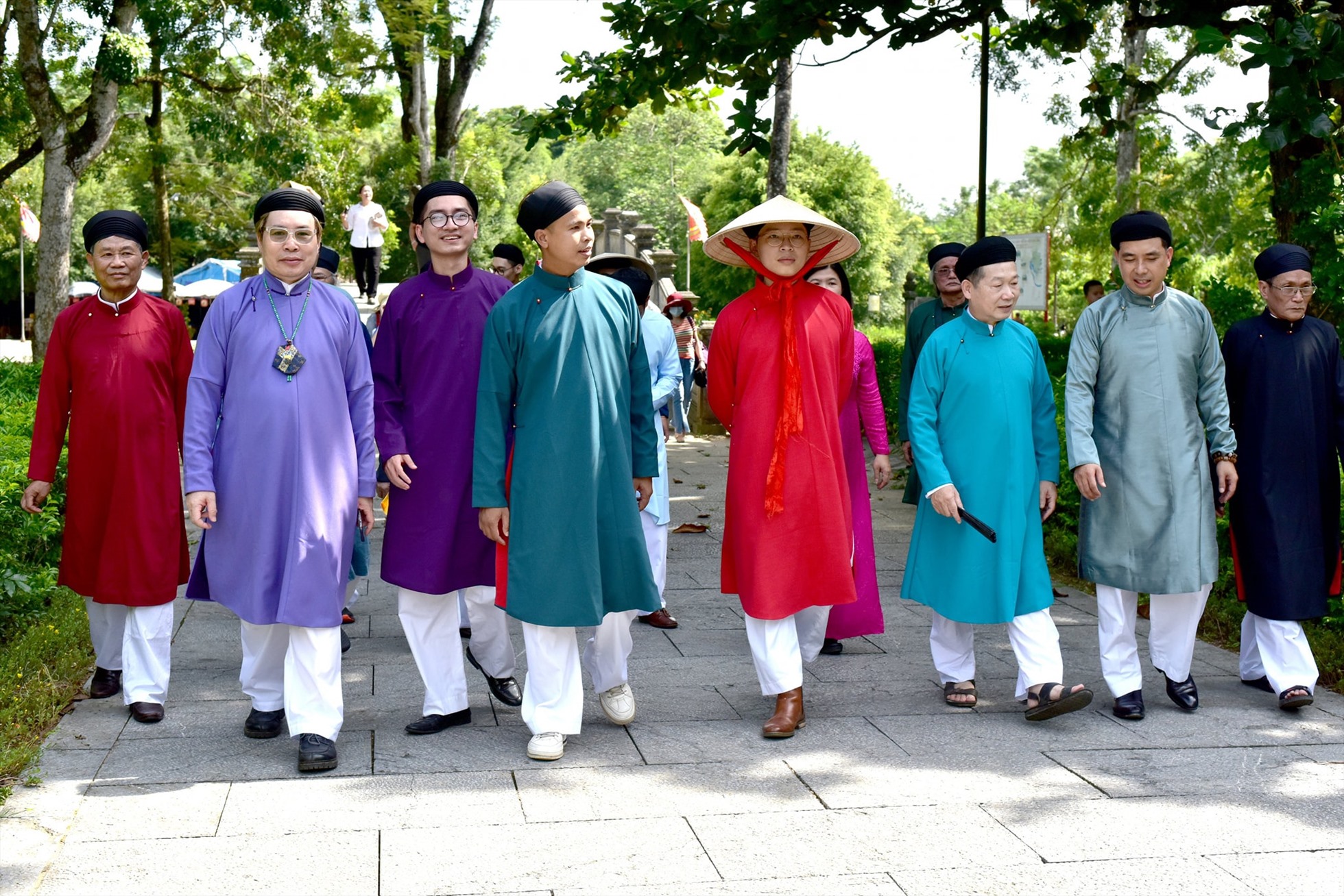 Họa sĩ Nguyễn Đức Bình (áo dài đỏ, giữa) cùng những người bạn, đồng nghiệp diện áo dài ngũ thân truyền thống. Ảnh: FBNV