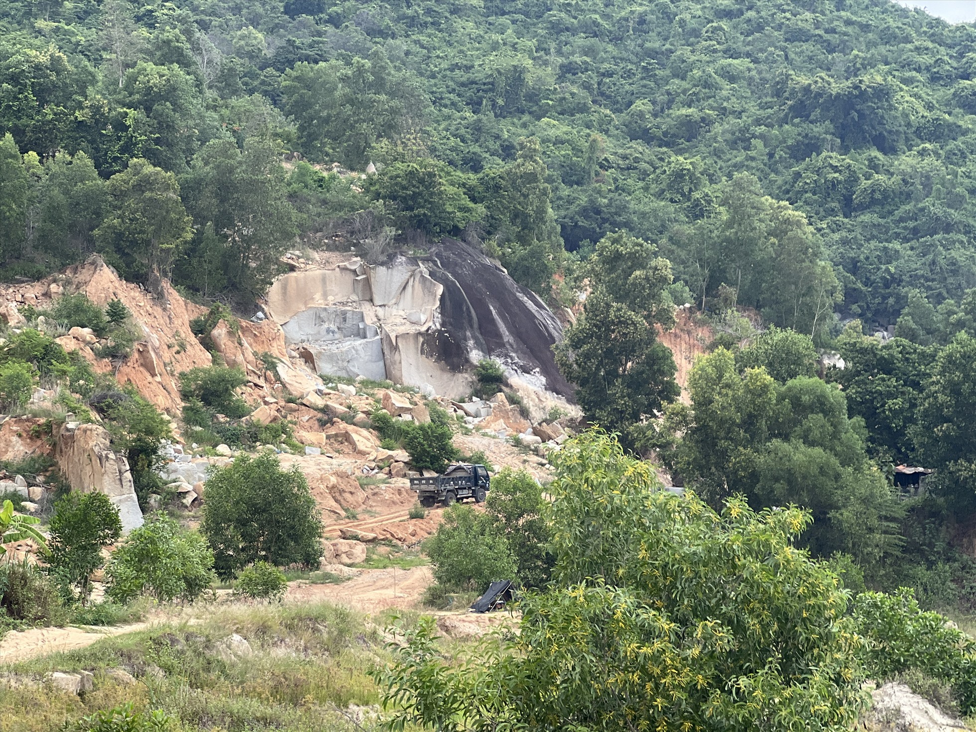 Đồi núi bị xẻ để mở đường cho xe chở đất đá vào mỏ khai thác.