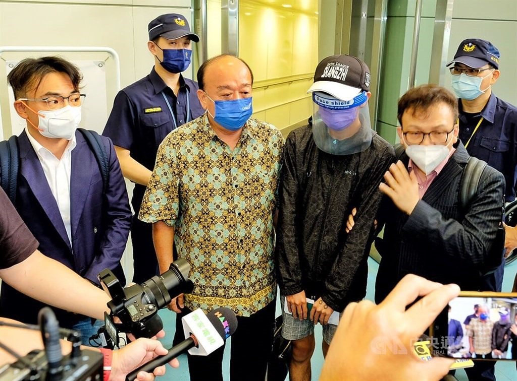 Một nạn nhân của đường dây buôn người (đeo tấm chắn) trở về Đài Loan từ Campuchia ngày 18.8.2022. Ảnh: CNA