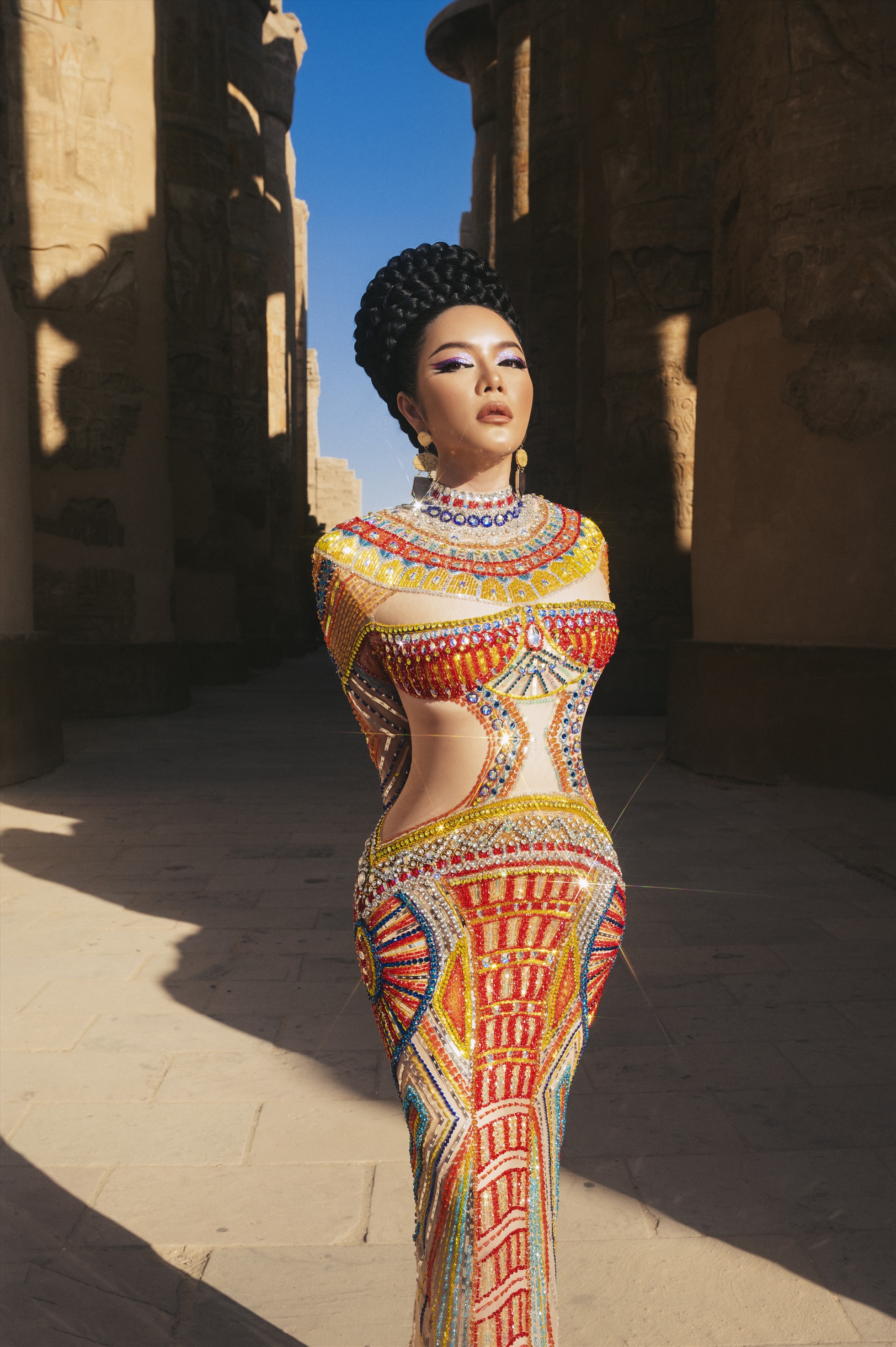 Trong bộ váy của Thượng Gia Kỳ, Lý Nhã Kỳ biến hóa thành nữ hoàng Nefertiti.. Bộ váy đính kết đá cầu kỳ, nhờ layout makeup đậm, tập trung vào sự sắc sảo của đôi mắt và phối thêm phụ kiện lấp lánh, nâng cầu vai. Ảnh: NSCC