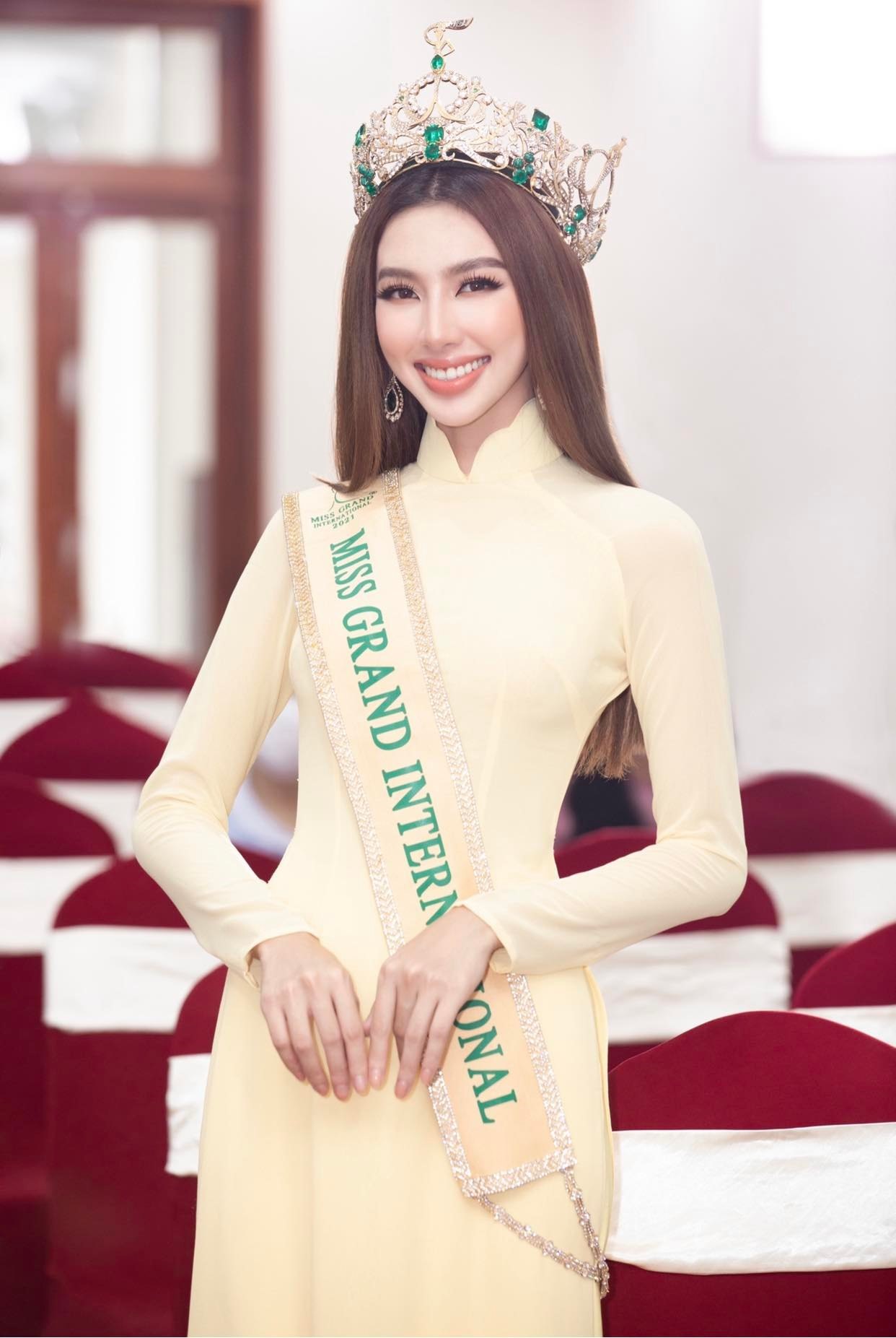 Sau đăng quang, Thùy Tiên diện trang phục áo dài từ NTK Ngô Nhật Huy trong buổi lễ diễu hành, Miss Grand International 2021 diện áo dài vàng trơn, đeo vương miện 12 tỷ. Ảnh: NSCC