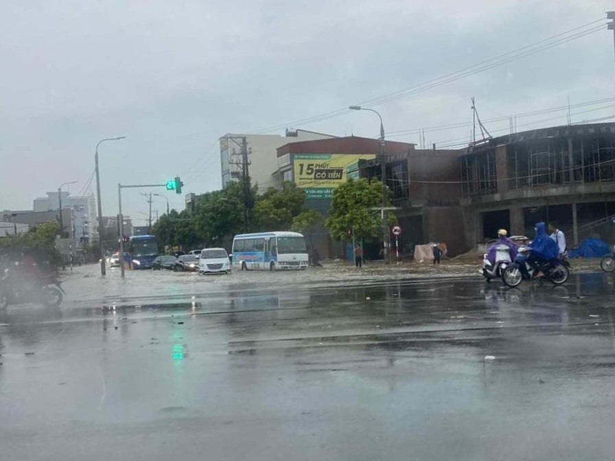 Sáng sớm ngày 26.8, mưa vẫn còn tiếp diễn, người dân tham gia giao thông khó khăn khi đi qua các ngã tư ngập nước.