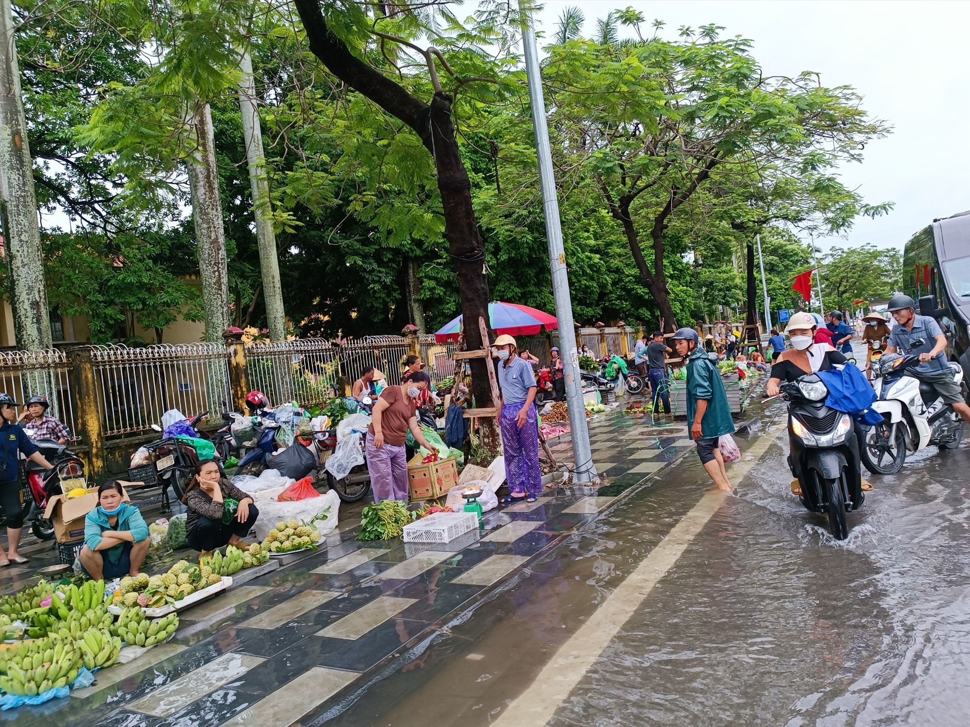 Nước ngập sâu ở phố Nguyễn Bình khiến các tiểu thương chợ Đổng Quốc Bình phải bày bán hàng ở vỉa hè đường Lạch Tray sáng nay 26.8. Ảnh: Băng Tâm