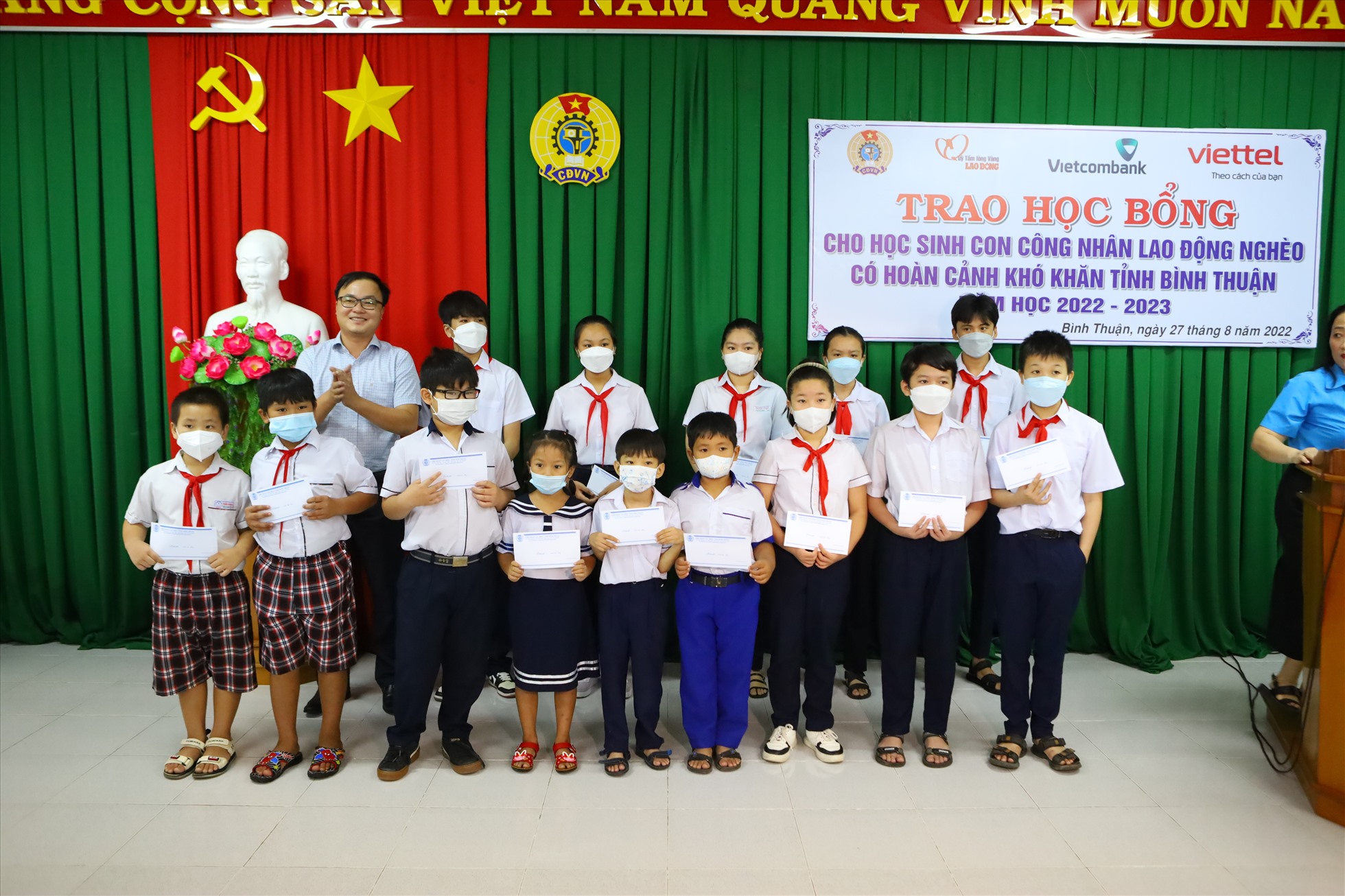 Đại diện Tập đoàn Công nghiệp - Viễn thông Quân đội (Viettel) tại Bình Thuận trao học bổng cho các cháu. Ảnh: DT