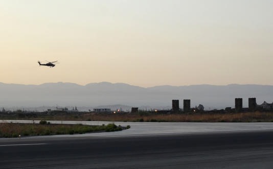 Trực thăng bay phía trên các tên lửa S-300 đặt tại căn cứ không quân của Nga ở Latakia. Ảnh: AFP