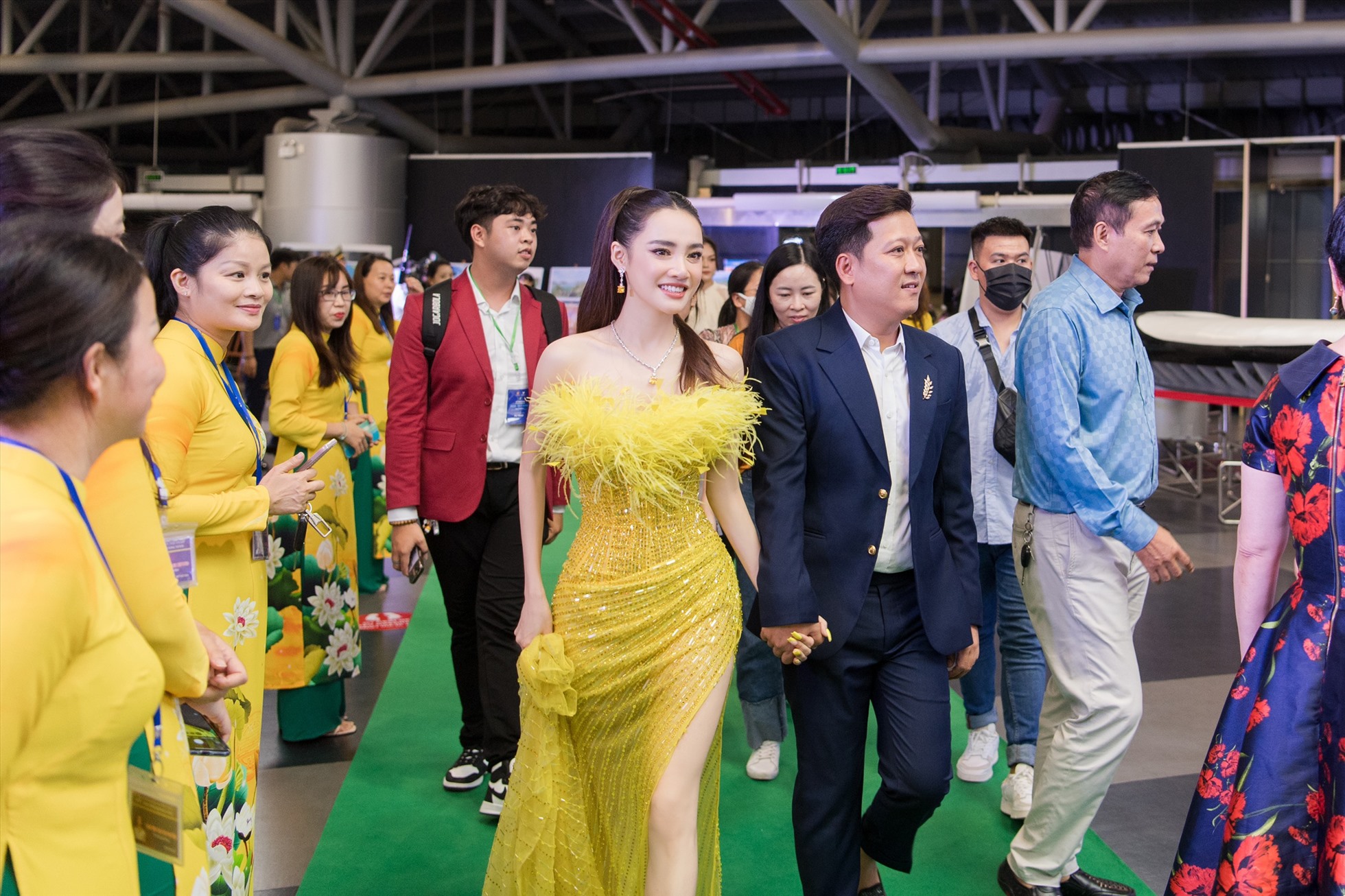Trong khi danh hài Trường Giang vẫn trung thành với bộ vest màu đen lịch lãm thì bà xã Nhã Phương lại vô cùng nổi bật với chiếc váy màu vàng của NTK Chung Thanh Phong. Ảnh: NSCC.