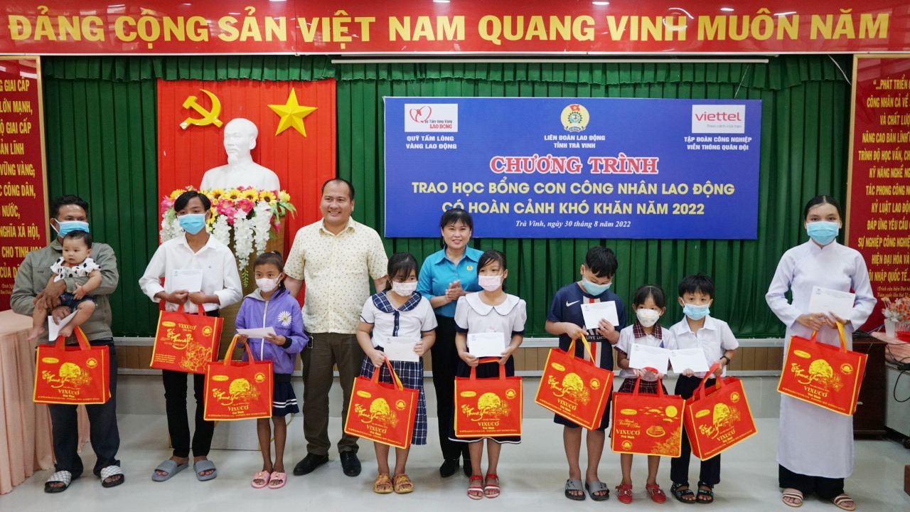 Bà Võ Thị Thu Oanh - Phó Chủ tịch LĐLĐ tỉnh Trà Vinh cùng đại diện nhà tài trợ trao học bổng và quà cho các cháu học sinh có hoàn cảnh khó khăn. Ảnh: Tạ Quang.