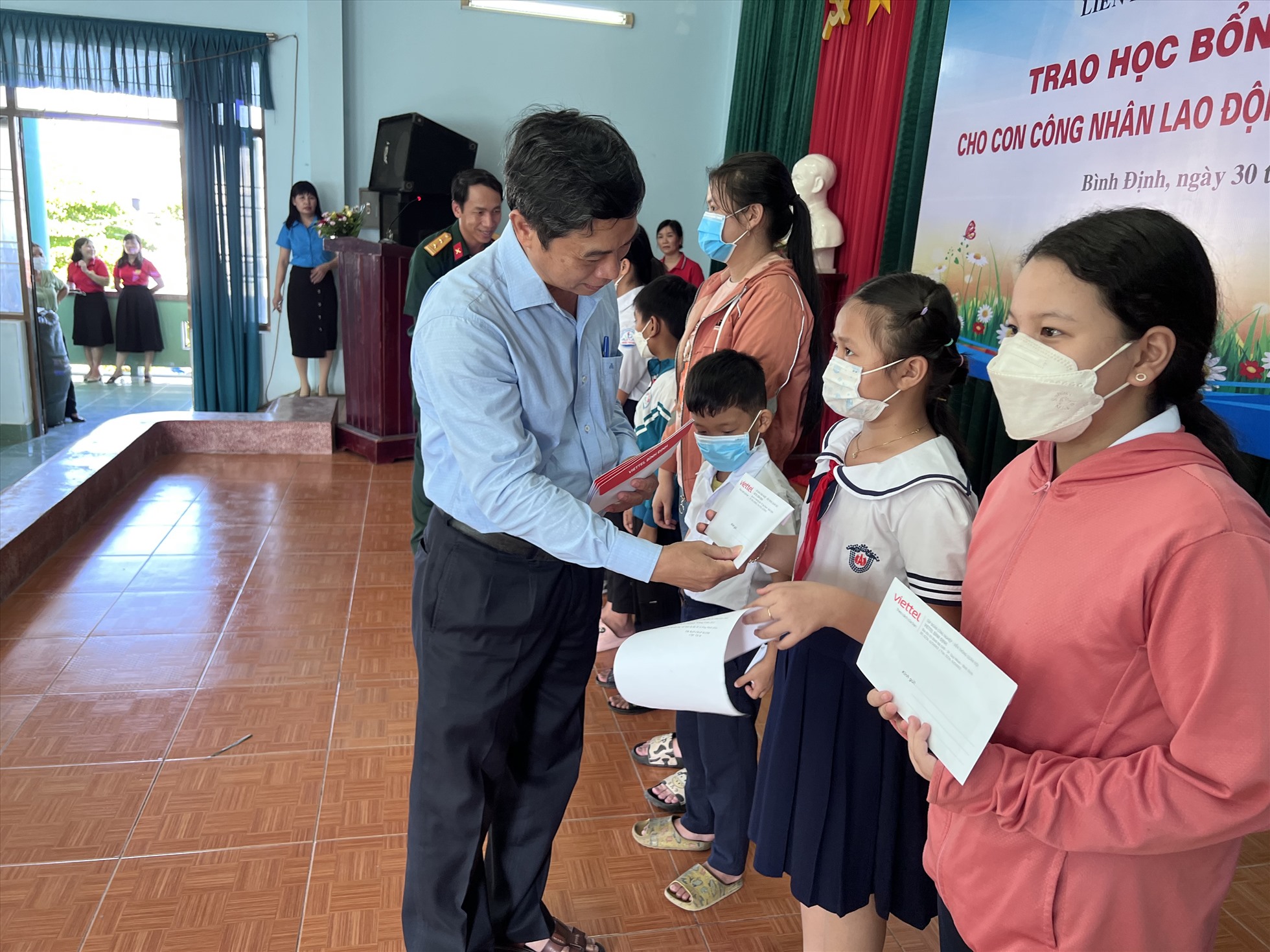 Ông Nguyễn Mạnh Hùng và đại diện Viettel Bình Định trao học bổng cho học sinh