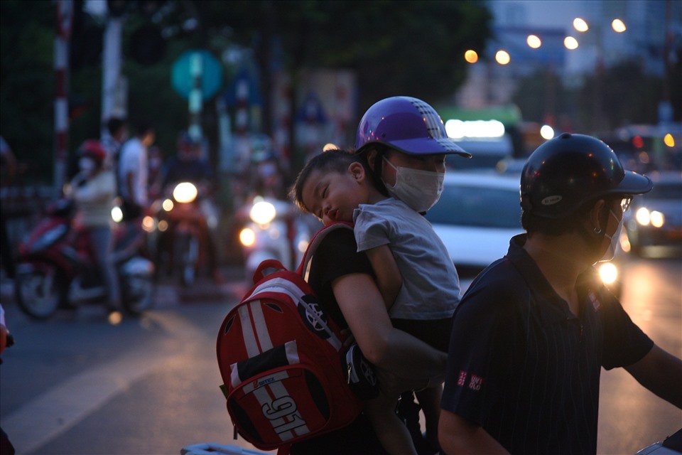 19h: Tại đường Giải Phóng đoạn gần Bến xe Nước Ngầm, nhiều người mệt mỏi vì ùn tắc, mất cả tiếng đồng hồ để di chuyển. Nhiều em bé ngủ thiếp đi trên lưng mẹ.