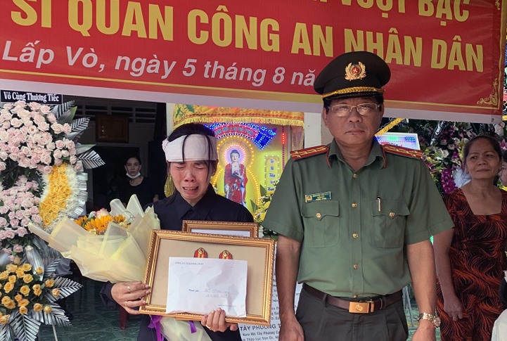 Đại tá Nguyễn Văn Hiểu trao quân hàm thiếu tá cho vợ đại úy Hồ Tấn Dương. Ảnh: CTV