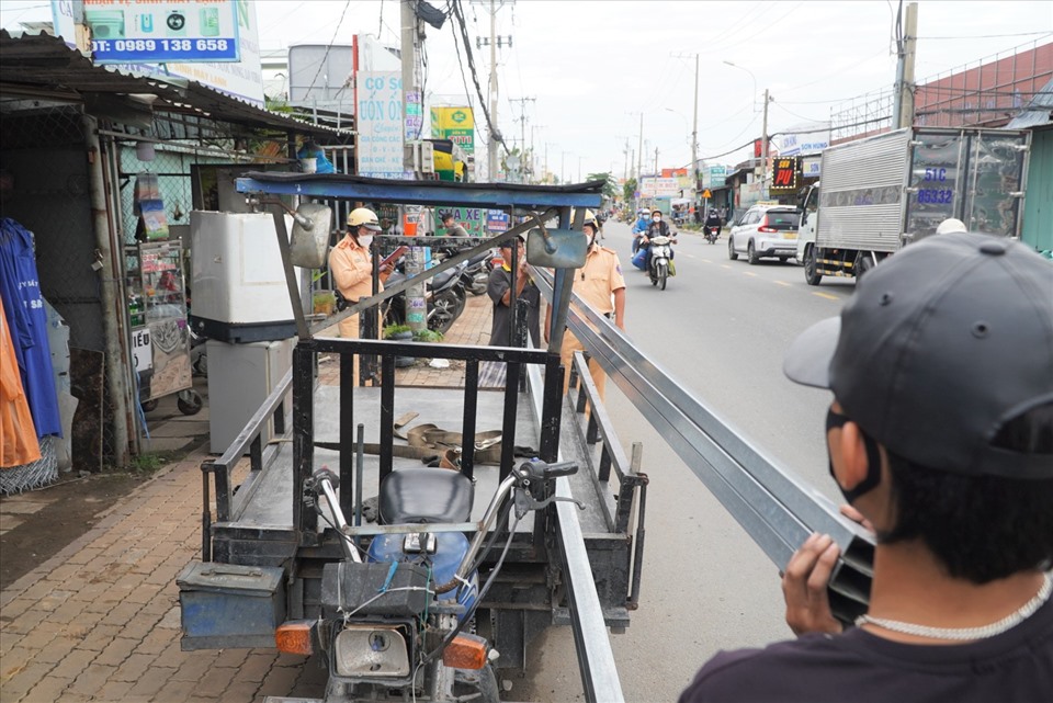 Lực lượng chức năng yêu cầu tài xế hạ hàng hóa xuống để tạm giữ phương tiện.