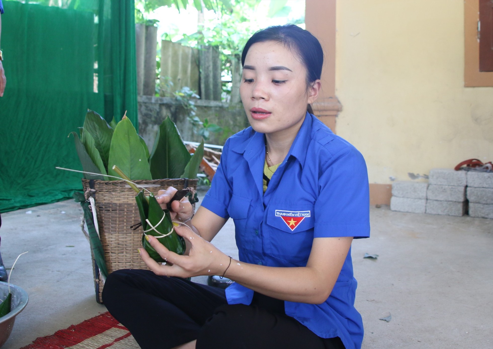 Nữ thanh niên người Thái đang gói bánh chuẩn bị cho mâm lễ, một công đoạn đòi hỏi kĩ thuật khéo léo. Ảnh: HV