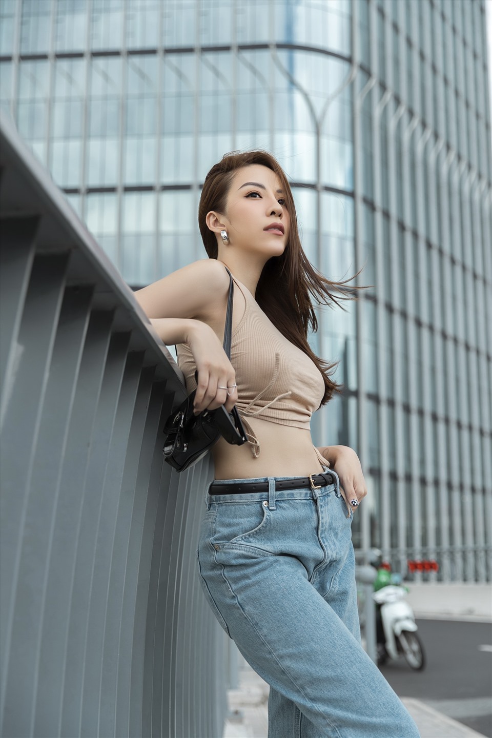 Trong bộ ảnh mới, nữ diễn viên gốc Cà Mau diện đồ trẻ trung với áo crop top, phối quần jeans, giày thể thao, kết hợp cùng túi xách đeo vai hợp mốt. Ảnh: Phan Tiến Vũ.