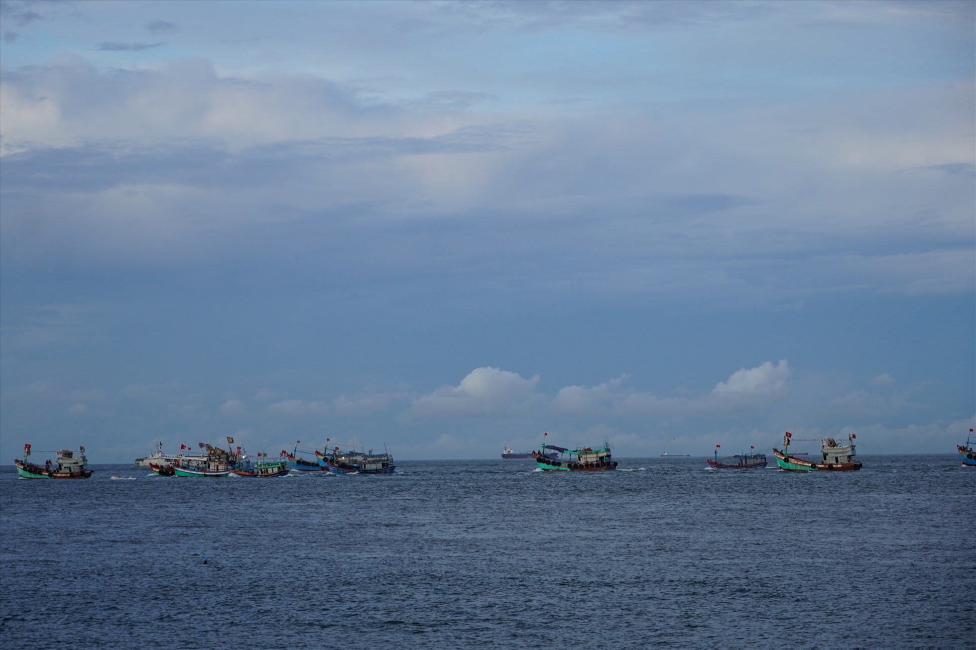 Hàng chục chiếc tàu cá nối đuôi nhau trên biển, cùng các phương tiện khác như du thuyền, tàu biển ... chở theo du khách, khách mời tham gia phần lễ Nghinh ông trên biển. Ảnh: T.A