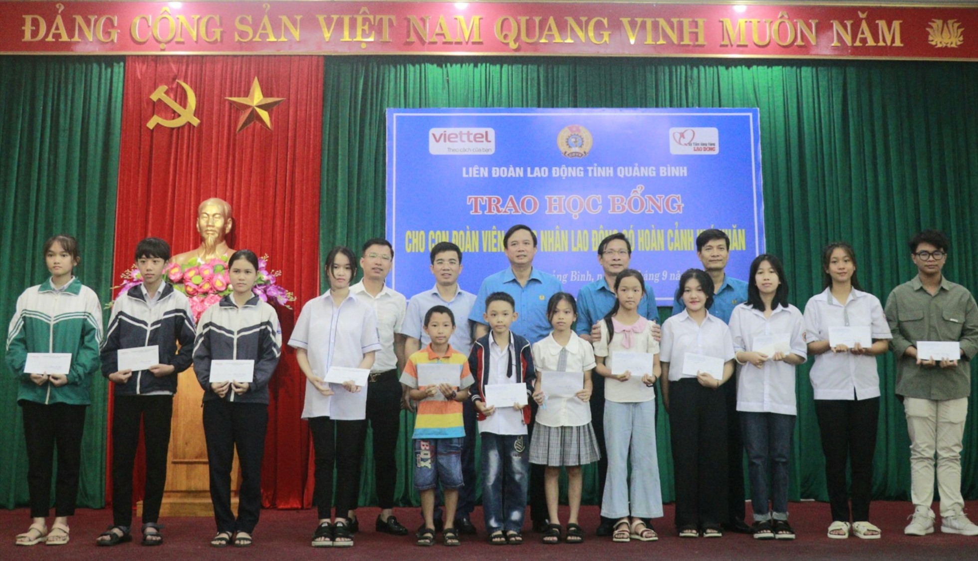 Đại diện Quỹ XHTT Tấm lòng vàng cùng lãnh đạo LĐLĐ tỉnh Quảng Bình và Viettel Quảng Bình trao học bổng cho học sinh khó khăn. Ảnh: LPL