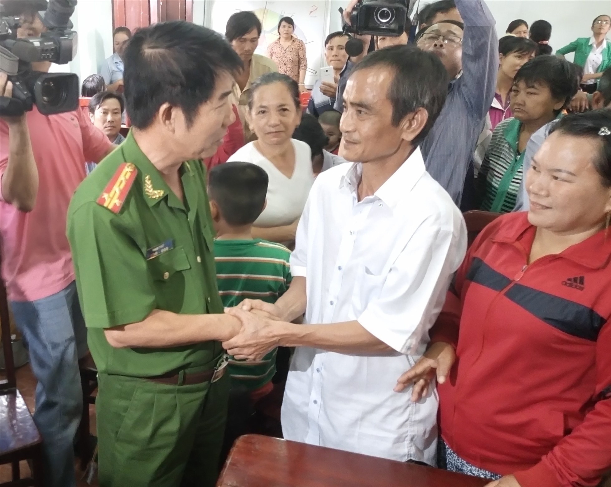 Đại tá Phạm Thật, Thủ trưởng Cơ quan CSĐT Công an Bình Thuận bắt tay ông Huỳnh Văn Nén trong ngày công bố xin lỗi ông Nén. Ảnh: CTV
