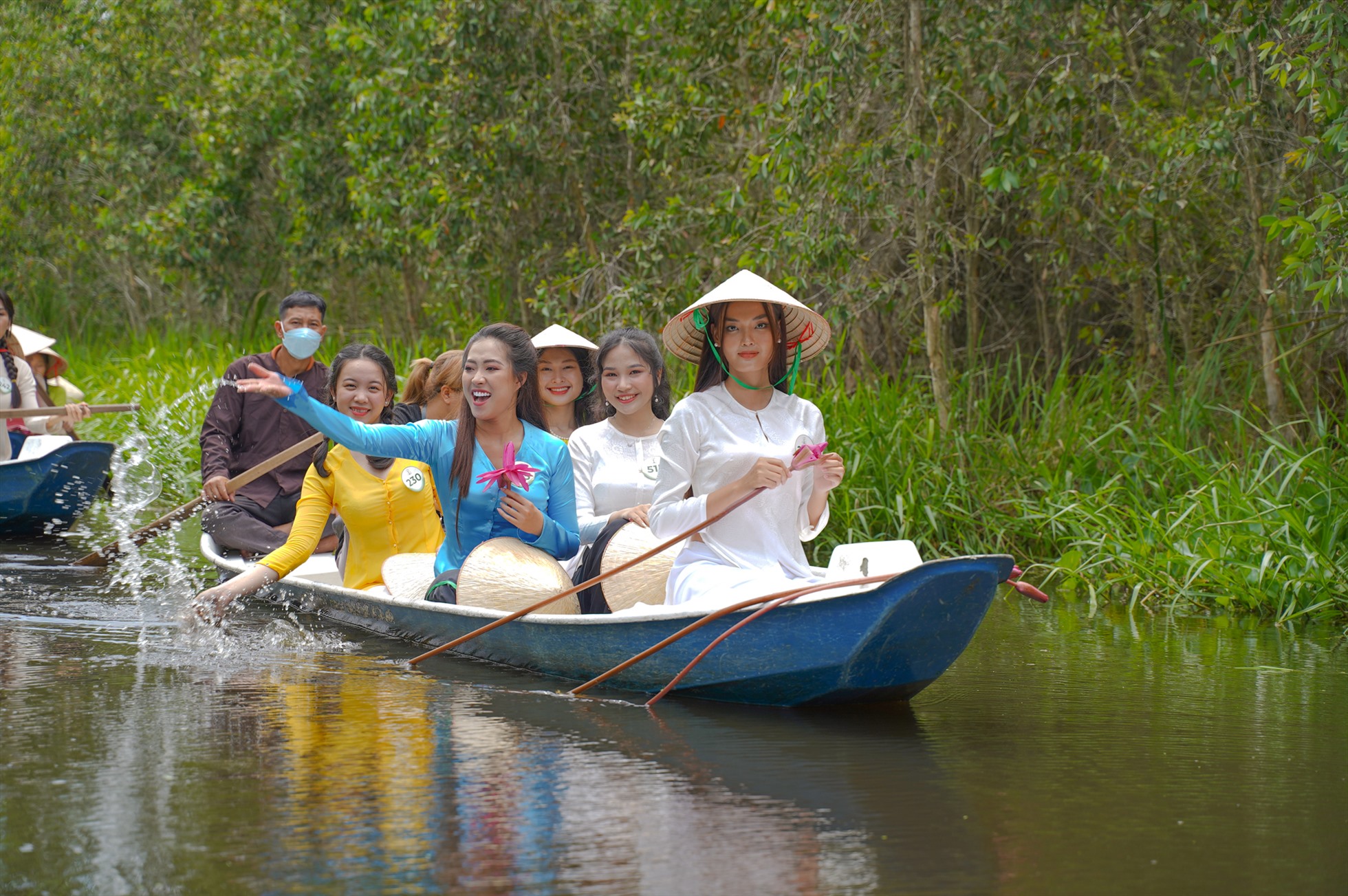 Dàn thí sinh “Hoa khôi Sông Vàm 2022” lênh đênh trên những chiếc thuyền ba lá xuôi theo dòng nước, cảm nhận không khí làng quê mộc mạc nơi đây. Ảnh: NSCC.